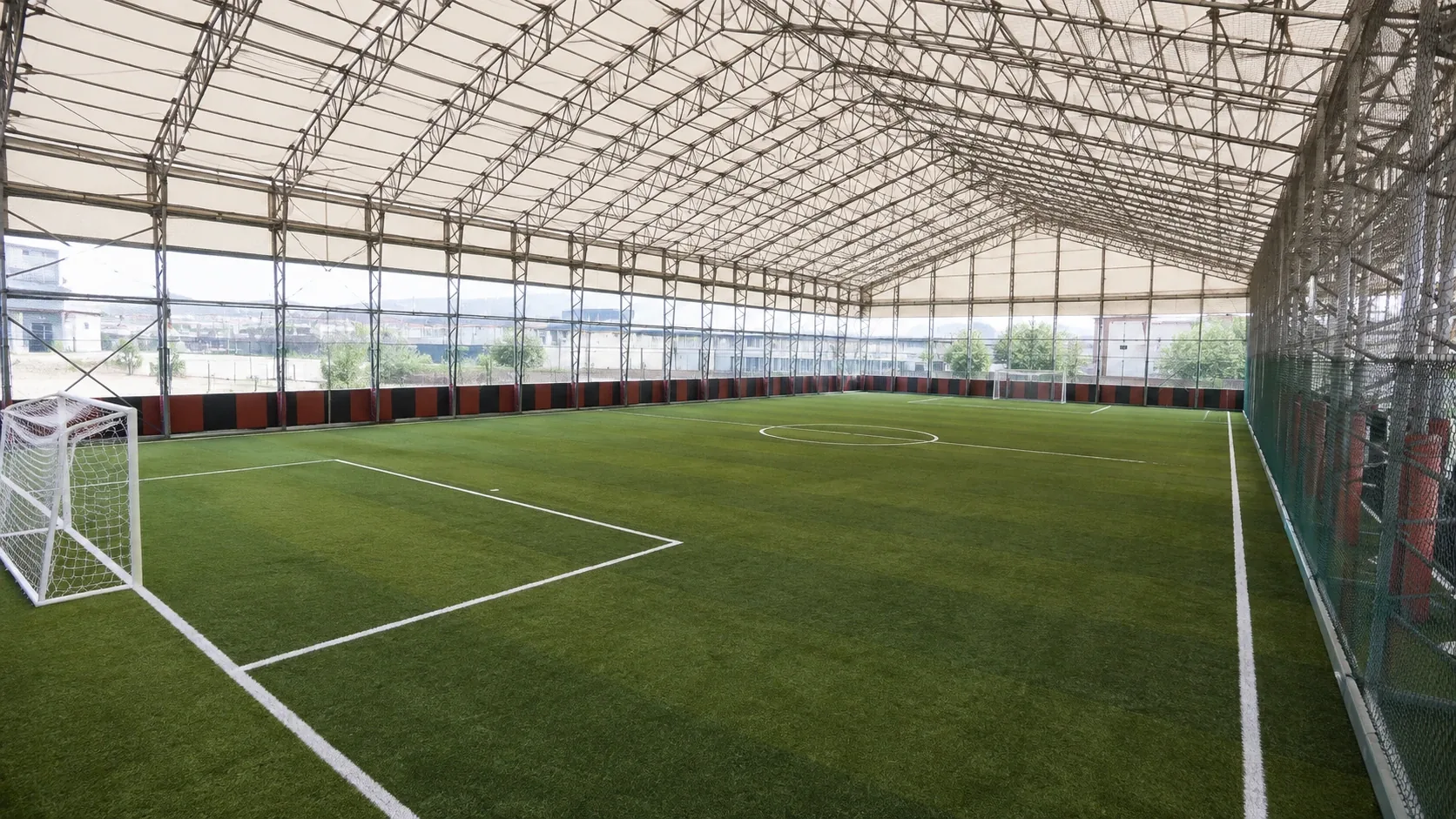 Kapalı halı saha projelerinde kullanılan sentetik spor zemini ve çevreleme altyapısını temsil eden saha görünümü