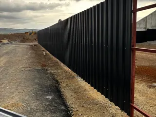 Aktif inşaat sahasında siyah trapez sac saha kapama uygulaması.